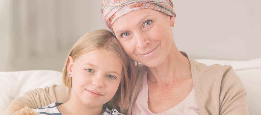 A woman with cancer and her daughter sitting on a couch